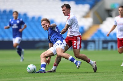 080826 - Cardiff City v Swindon Town, EFL Carabao Cup - Isaak Davies of Cardiff City and Mitchell Clark of Swindon Town compete for the ball