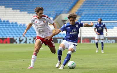 080826 - Cardiff City v Swindon Town, EFL Carabao Cup - Cian Ashford of Cardiff City holds off Stephan Negru of Swindon Town