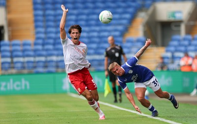 080826 - Cardiff City v Swindon Town, EFL Carabao Cup - Isaak Davies of Cardiff City and Stephan Negru of Swindon Town compete for the ball