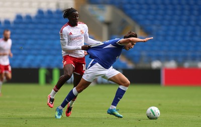 080826 - Cardiff City v Swindon Town, EFL Carabao Cup - Joel Colwill of Cardiff City is brought down by James Debayo of Swindon Town