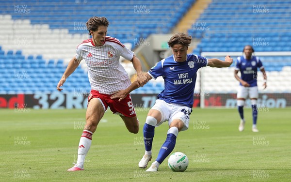 080826 - Cardiff City v Swindon Town, EFL Carabao Cup - Cian Ashford of Cardiff City holds off Stephan Negru of Swindon Town
