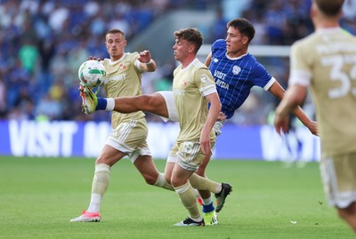 120825 - Cardiff City v Swindon Town, EFL Carabao Cup, Round 1 - Rubin Colwill of Cardiff City wins the ball from Billy Bodin of Swindon Town and Gavin Kilkenny of Swindon Town