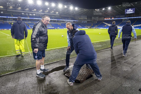 021122 - Cardiff City v Watford - Sky Bet Championship - Cardiff City Stadium ground staff inspect the drainage system after a downpour ahead of the match 