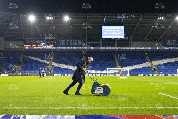 021122 - Cardiff City v Watford - Sky Bet Championship - Cardiff City Stadium ground staff roll the pitch after a downpour