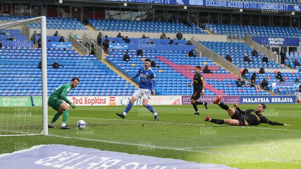 130321 Cardiff City v Watford, Sky Bet Championship - Francisco Sierralta of Watford puts the ball past his own goalkeeper Daniel Bachmann to score an own goal as Kieffer Moore of Cardiff City looks on