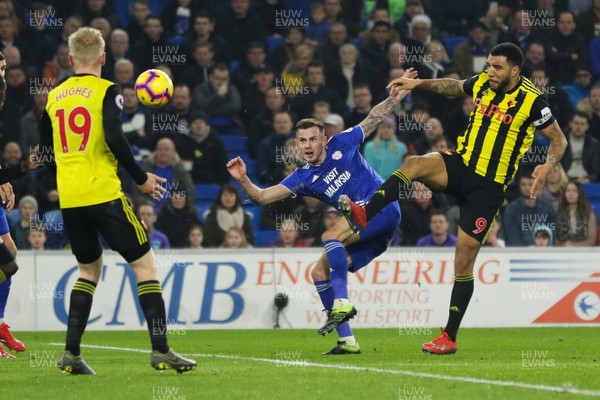 220219 - Cardiff City v Watford, Premier League - Joe Ralls of Cardiff City fires a shot at goal as Troy Deeney of Watford challenges