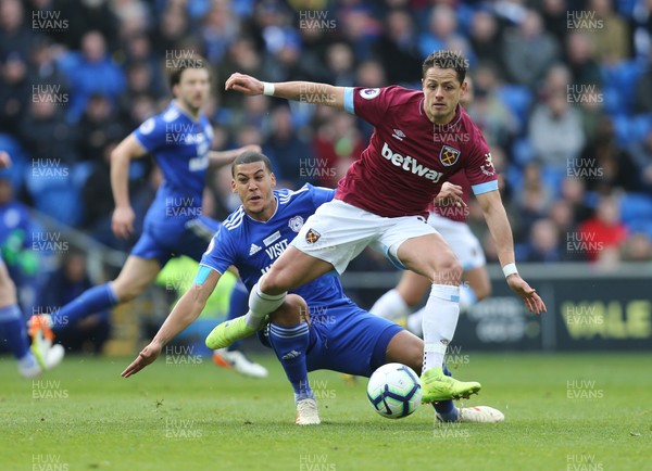 090319 - Cardiff City v West Ham United, Premier League - Lee Peltier of Cardiff City challenges Chicharito of West Ham United