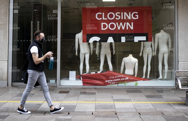 040321 - Picture shows a man walking past a closed down shop on The Hayes, Cardiff today as the current coronavirus restrictions are set to stay in place