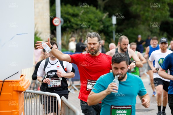 011023 - Principality Building Society Cardiff Half Marathon 2023 - Cardiff Bay - Runners throwing water bottles into recycling bins