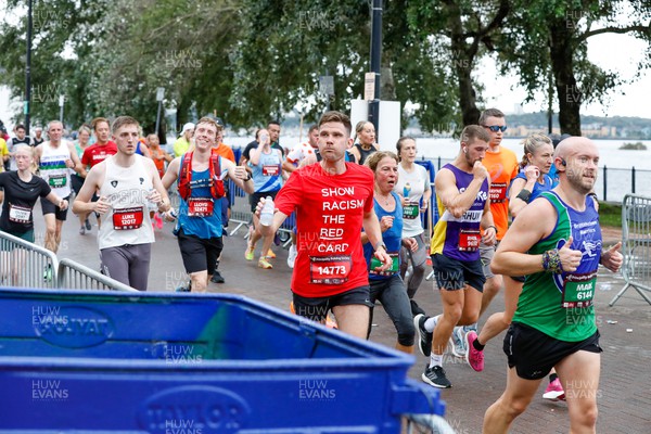 011023 - Principality Building Society Cardiff Half Marathon 2023 - Cardiff Bay - Runners throwing water bottles into recycling bins