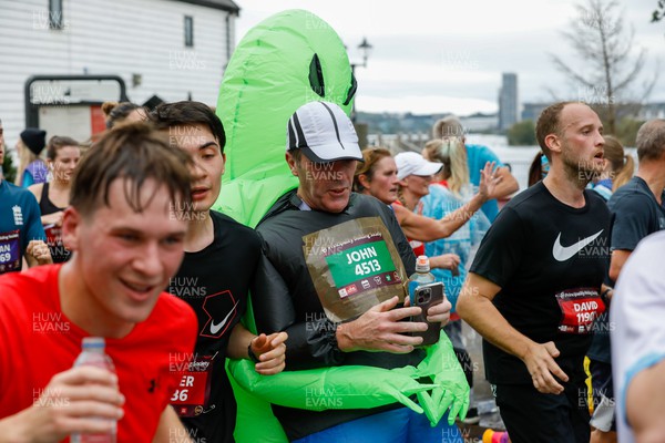 011023 - Principality Building Society Cardiff Half Marathon 2023 - Cardiff Bay - Runner wearing costume of alien carrying a man