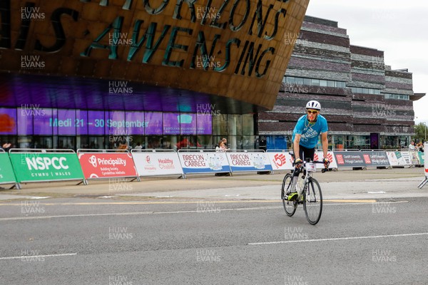 011023 - Principality Building Society Cardiff Half Marathon 2023 - Cardiff Bay - Volunteer Extra Miler rides past Wales Millennium Centre