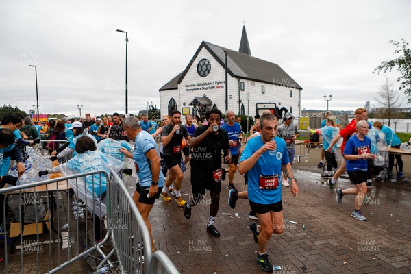 011023 - Principality Building Society Cardiff Half Marathon 2023 - Cardiff Bay - Extra Miler volunteers hand out water and gels at Norwegian Church