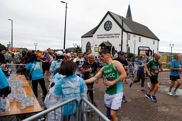 011023 - Principality Building Society Cardiff Half Marathon 2023 - Cardiff Bay - Extra Miler volunteers hand out water and gels at Norwegian Church