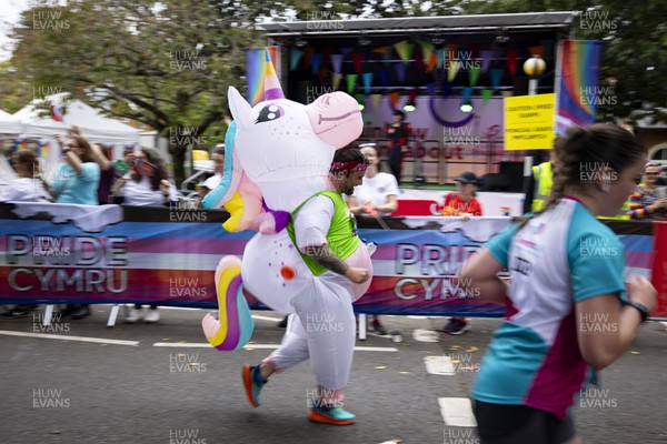 011023 - Principality Building Society Cardiff Half Marathon 2023 - Roath Park and Lake - Runner dressed as unicorn goes past Rainbow Roundabout