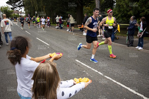 011023 - Principality Building Society Cardiff Half Marathon 2023 - Roath Park and Lake - Supporters offer orange slices to runners