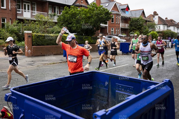 011023 - Principality Building Society Cardiff Half Marathon 2023 - Roath Park and Lake - Runners throwing water bottles into recycling bins