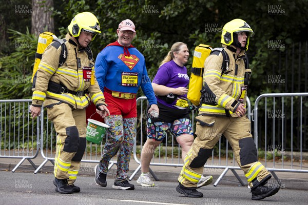 011023 - Principality Building Society Cardiff Half Marathon 2023 - Roath Park and Lake - Runner dressed as Superman with firefighters