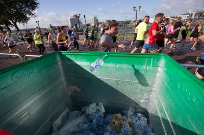 061019 - Cardiff Half Marathon 2019 - Runners recycle their water bottles as they make their way through Cardiff Bay, Roald Dahl Plas and past the Wales Millennium Centre at the halfway point of the race