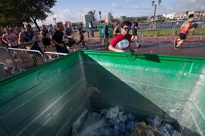 061019 - Cardiff Half Marathon 2019 - Runners recycle their water bottles as they make their way through Cardiff Bay, Roald Dahl Plas and past the Wales Millennium Centre at the halfway point of the race