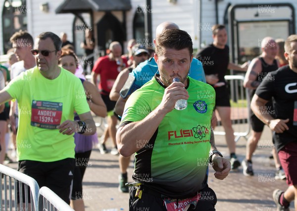 061019 - Cardiff Half Marathon 2019 - Runners recycle their water bottles as they make their way through Cardiff Bay, Roald Dahl Plas and past the Wales Millennium Centre at the halfway point of the race