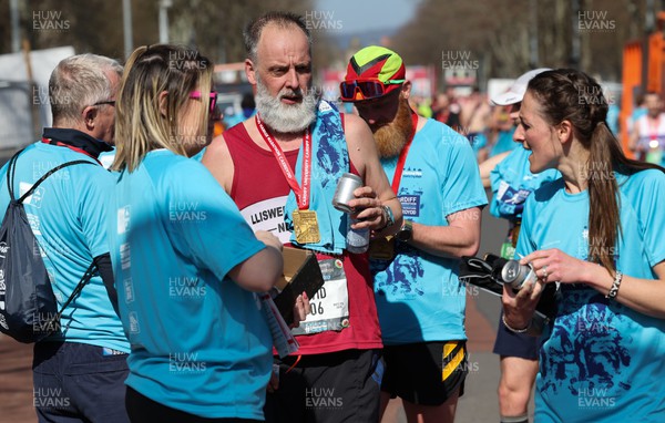 270322 - Cardiff University Cardiff Half Marathon - Kombucha cans and bananas are handed out at the end of the race