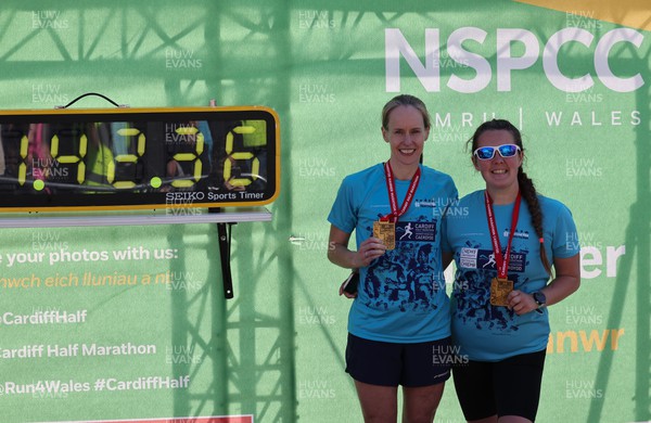 270322 - Cardiff University Cardiff Half Marathon - Runners pose with the NSPCC Timing board for commemorative photographs