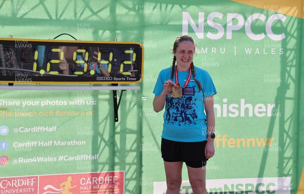 270322 - Cardiff University Cardiff Half Marathon - Runners pose with the NSPCC Timing board for commemorative photographs