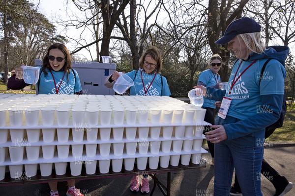 270322 - Cardiff University Cardiff Half Marathon - Volunteers prepare paper cups of water at Roath Park