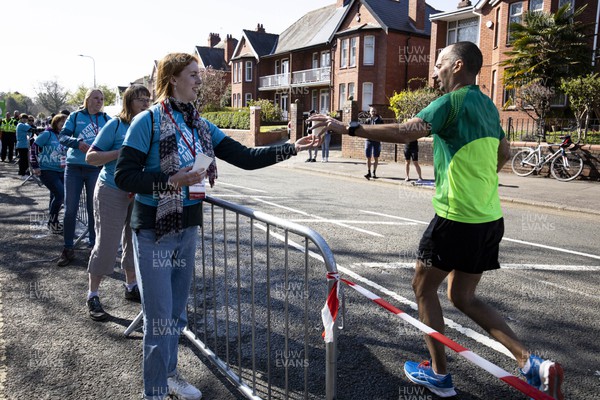 270322 - Cardiff University Cardiff Half Marathon - Volunteers hand out water at Roath Park