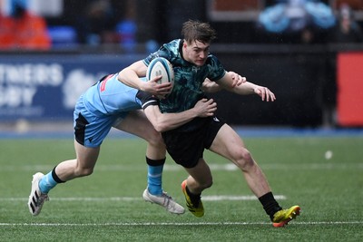 230225 - Cardiff Rugby U18s v Ospreys U18s - Regional Age-Grade Championship finals - Noah Mason of Ospreys U18s is challenged by Rhys Cummings of Cardiff Rugby