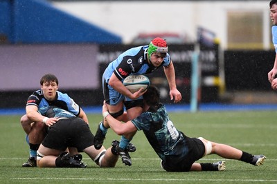 230225 - Cardiff Rugby U18s v Ospreys U18s - Regional Age-Grade Championship finals - Alfie Prygodzicz of Cardiff Rugby is challenged by Elis Cox of Ospreys U18s