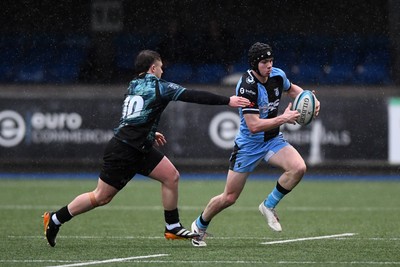 230225 - Cardiff Rugby U18s v Ospreys U18s - Regional Age-Grade Championship finals - Rhys Cummings of Cardiff Rugby is challenged by Logan Jones of Ospreys U18s