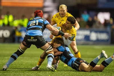 261225 - Cardiff Rugby v Dragons RFC - United Rugby Championship - Rio Dyer of Dragons is tackled by Jacob Beetham of Cardiff Rugby and Liam Botham of Cardiff Rugby