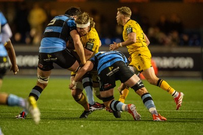 261225 - Cardiff Rugby v Dragons RFC - United Rugby Championship - Aaron Wainwright of Dragons I tackled by Rory Thornton of Cardiff Rugby and Alun Lawrence of Cardiff Rugby