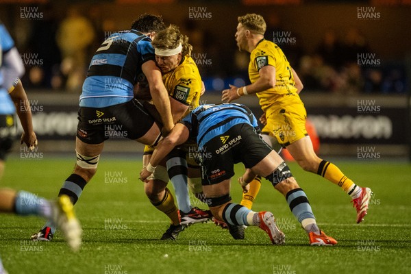 261225 - Cardiff Rugby v Dragons RFC - United Rugby Championship - Aaron Wainwright of Dragons I tackled by Rory Thornton of Cardiff Rugby and Alun Lawrence of Cardiff Rugby