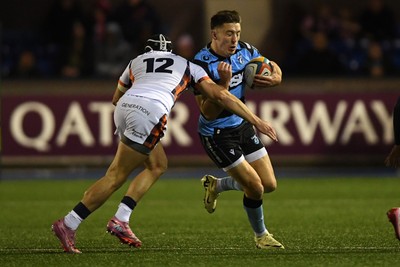 251025 - Cardiff Rugby v Edinburgh Rugby - United Rugby Championship - Josh Adams of Cardiff Rugby is challenged by James Lang of Edinburgh