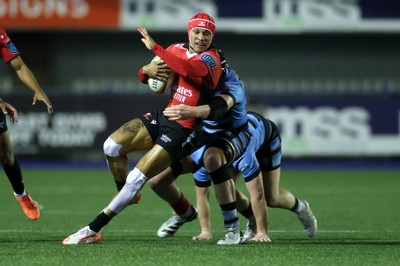 210325 - Cardiff Rugby v Emirates Lions - United Rugby Championship - Edwill van der Merwe of Lions is tackled by Rory Jennings and Seb Davies of Cardiff 