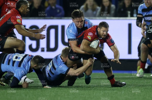 210325 - Cardiff Rugby v Emirates Lions - United Rugby Championship - Marius Louw of Lions is tackled by Johan Mulder and Alex Mann of Cardiff 