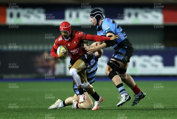 210325 - Cardiff Rugby v Emirates Lions - United Rugby Championship - Edwill van der Merwe of Lions is tackled by Rory Jennings and Seb Davies of Cardiff 