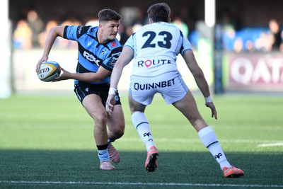 240426 - Cardiff Rugby v Ospreys - United Rugby Championship - Callum Sheedy of Cardiff Rugby is challenged by Max Nagy of Ospreys