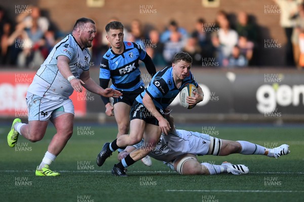 240426 - Cardiff Rugby v Ospreys - United Rugby Championship - Tom Bowen of Cardiff Rugby is challenged by Steffan Thomas of Ospreys