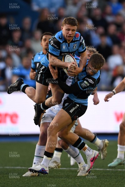 240426 - Cardiff Rugby v Ospreys - United Rugby Championship - Tom Bowen of Cardiff Rugby is challenged by Jac Morgan of Ospreys