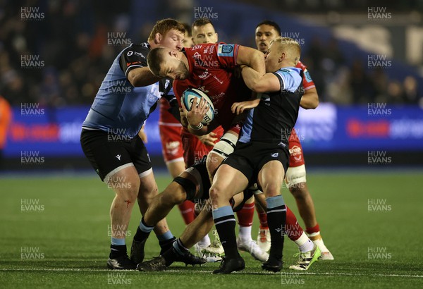 021223 - Cardiff Rugby v Scarlets - United Rugby Championship - Alex Craig of Scarlets is tackled by Rhys Carre and Tinus de Beer of Cardiff 