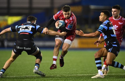 070123 - Cardiff v Scarlets - United Rugby Championship - Steff Evans of Scarlets is tackled by Mason Grady and Ben Thomas of Cardiff