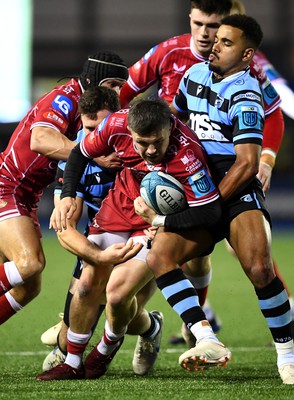 070123 - Cardiff v Scarlets - United Rugby Championship - Steff Evans of Scarlets is tackled by Mason Grady and Ben Thomas of Cardiff