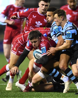 070123 - Cardiff v Scarlets - United Rugby Championship - Steff Evans of Scarlets is tackled by Mason Grady and Ben Thomas of Cardiff