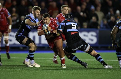 070123 - Cardiff Rugby v Scarlets - United Rugby Championship - Javan Sebastian of Scarlets is tackled by Thomas Young and Seb Davies of Cardiff