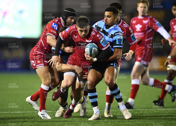 070123 - Cardiff v Scarlets - United Rugby Championship - Steff Evans of Scarlets is tackled by Mason Grady and Ben Thomas of Cardiff