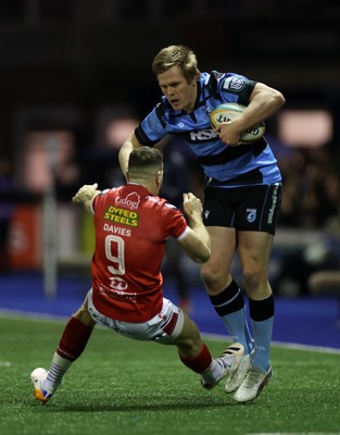 191225 - Cardiff Rugby v Scarlets - United Rugby Championship - Dan Thomas of Cardiff is tackled by Gareth Davies of Scarlets 